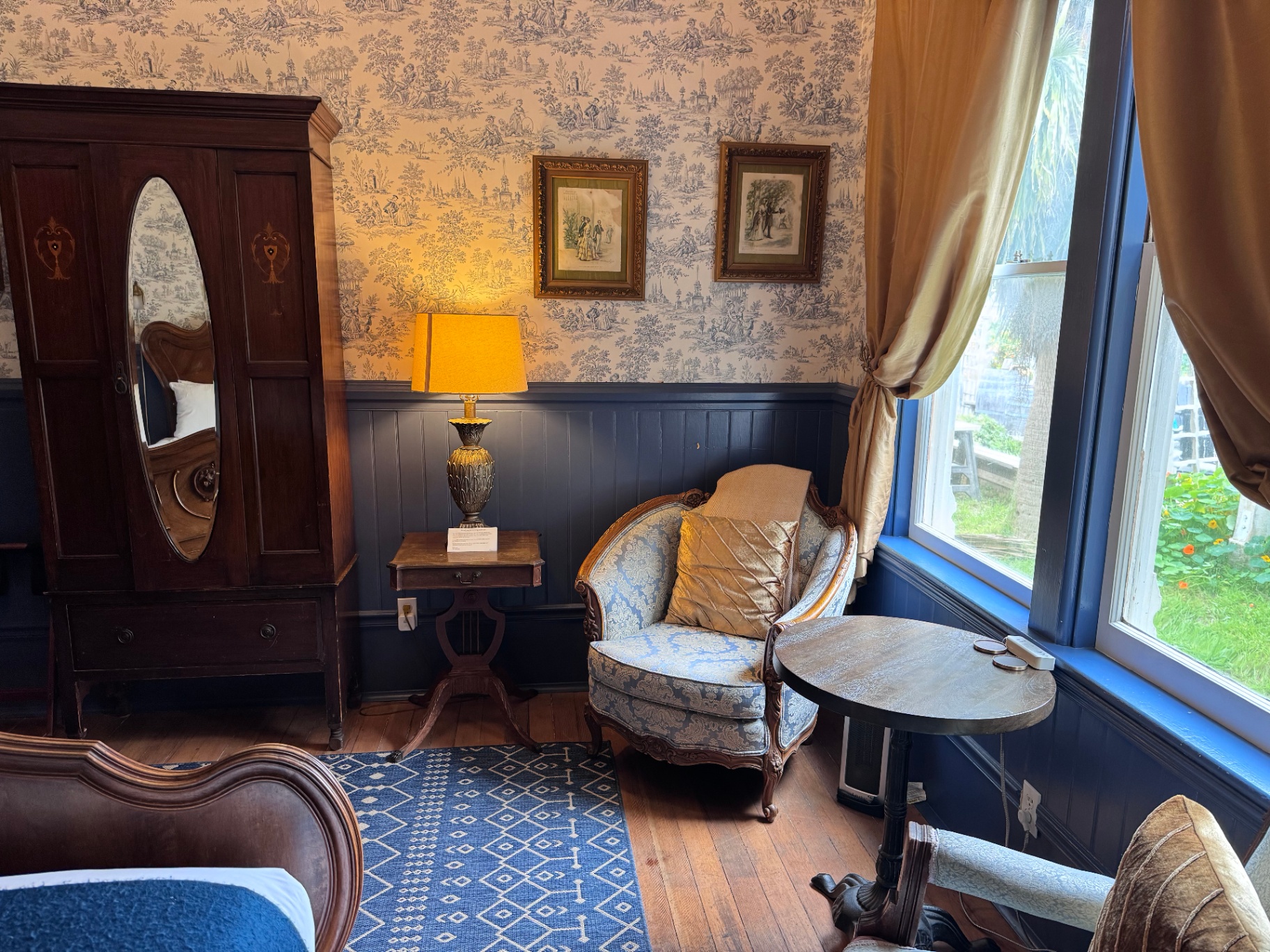 Weller House sitting area with toile wallpaper and antique armoire