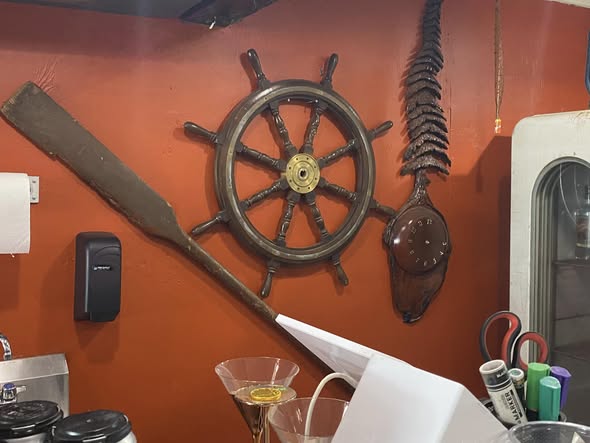 Ship’s wheel and oar mounted on the wall at Schnaubelt Distillery