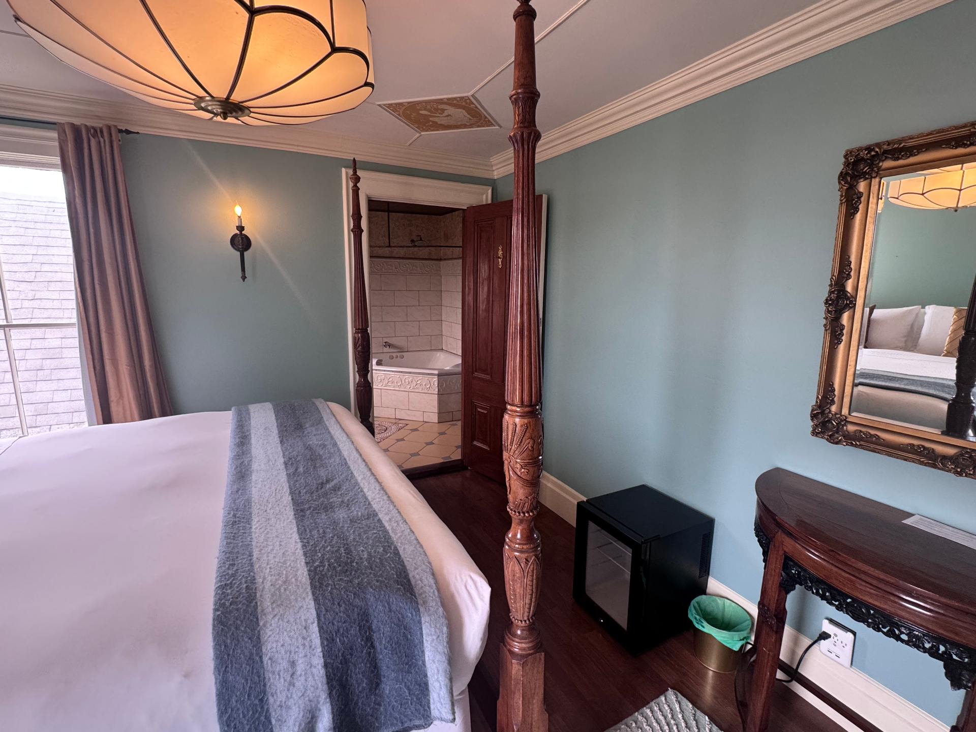 Weller House bedroom with four-poster bed and view into bathroom