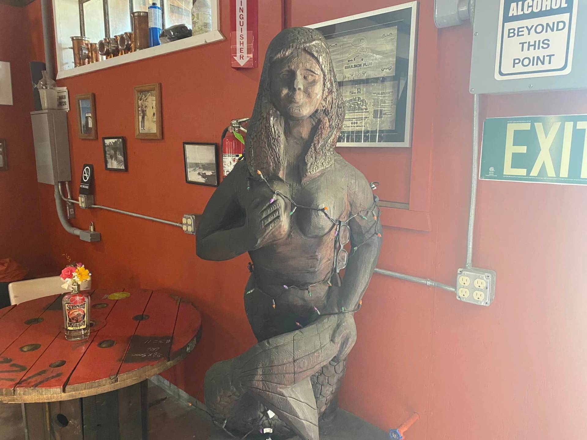 Carved wooden mermaid statue inside Schnaubelt Distillery